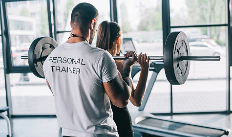 Personal Trainer helping Client workout